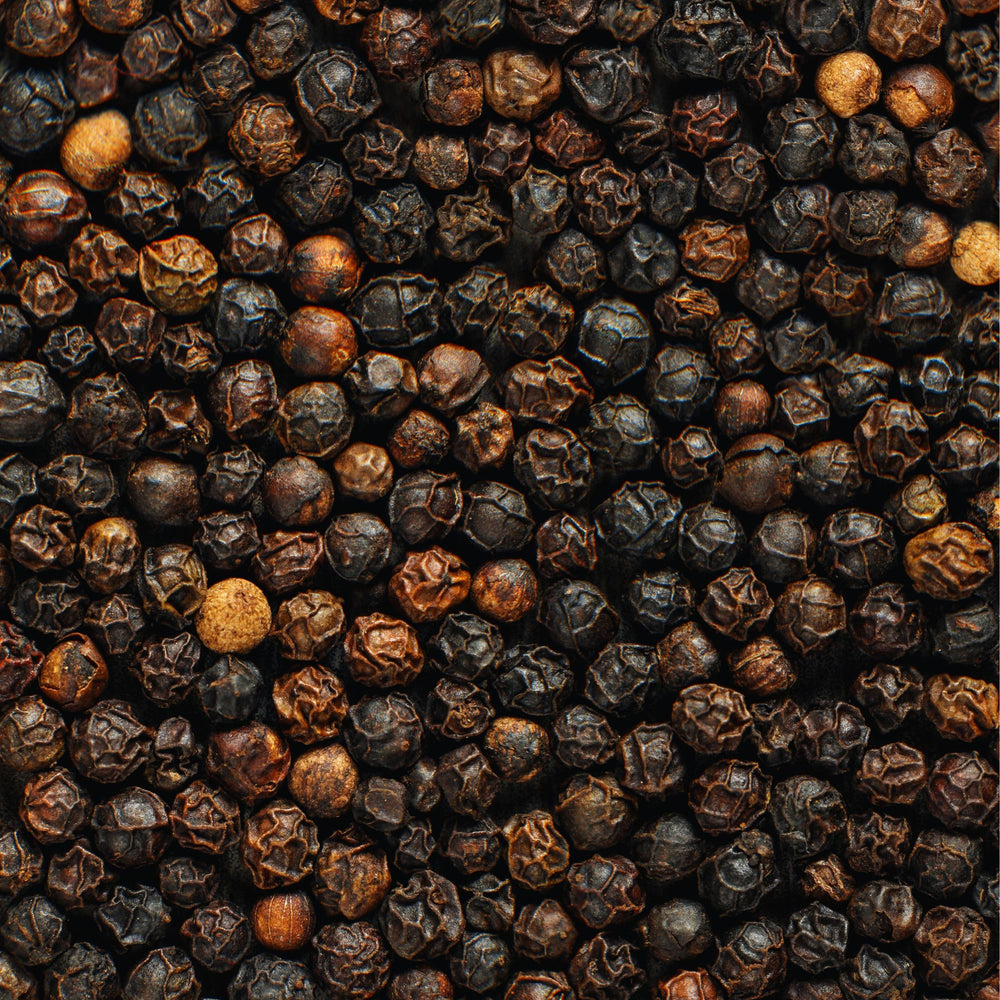 a sea of dried black peppercorns seen from a graphic overhead angle