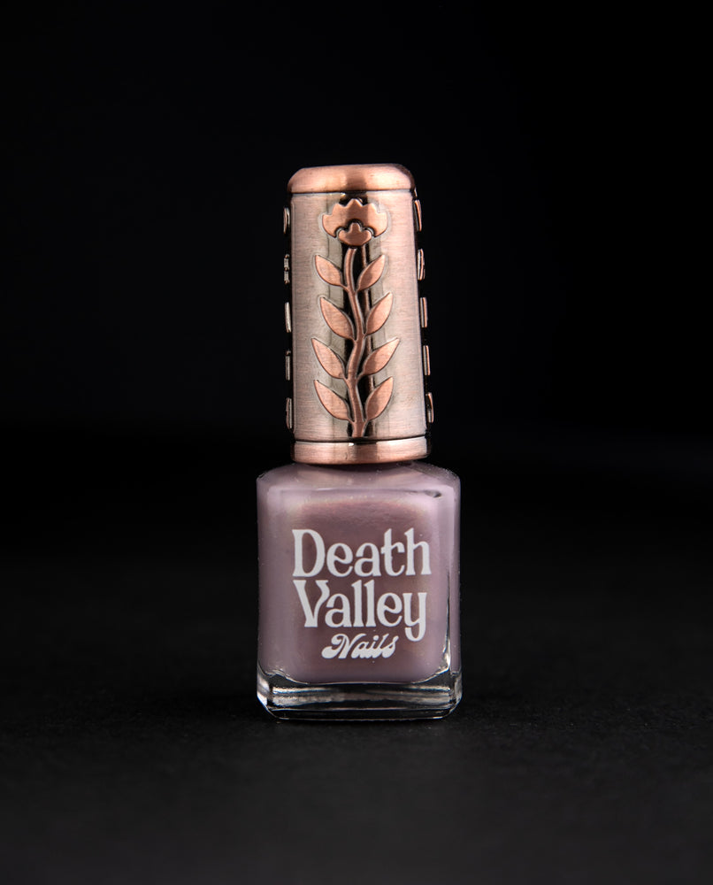 "Aliens" nail polish against black background. The polish is a shimmery purple-grey colour.