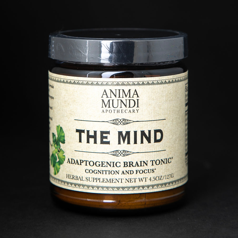 Amber glass jar with black lid of Anima Mundi's "The Mind" herbal supplement. The cream label reads "Adaptogenic brain tonic"