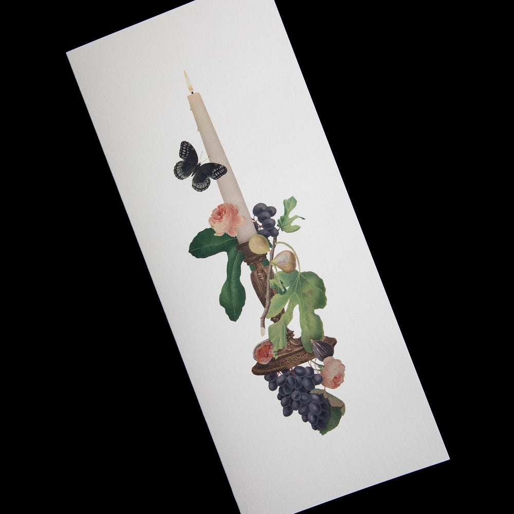 long narrow white card with candle and botanical illustration, shown against a black backdrop