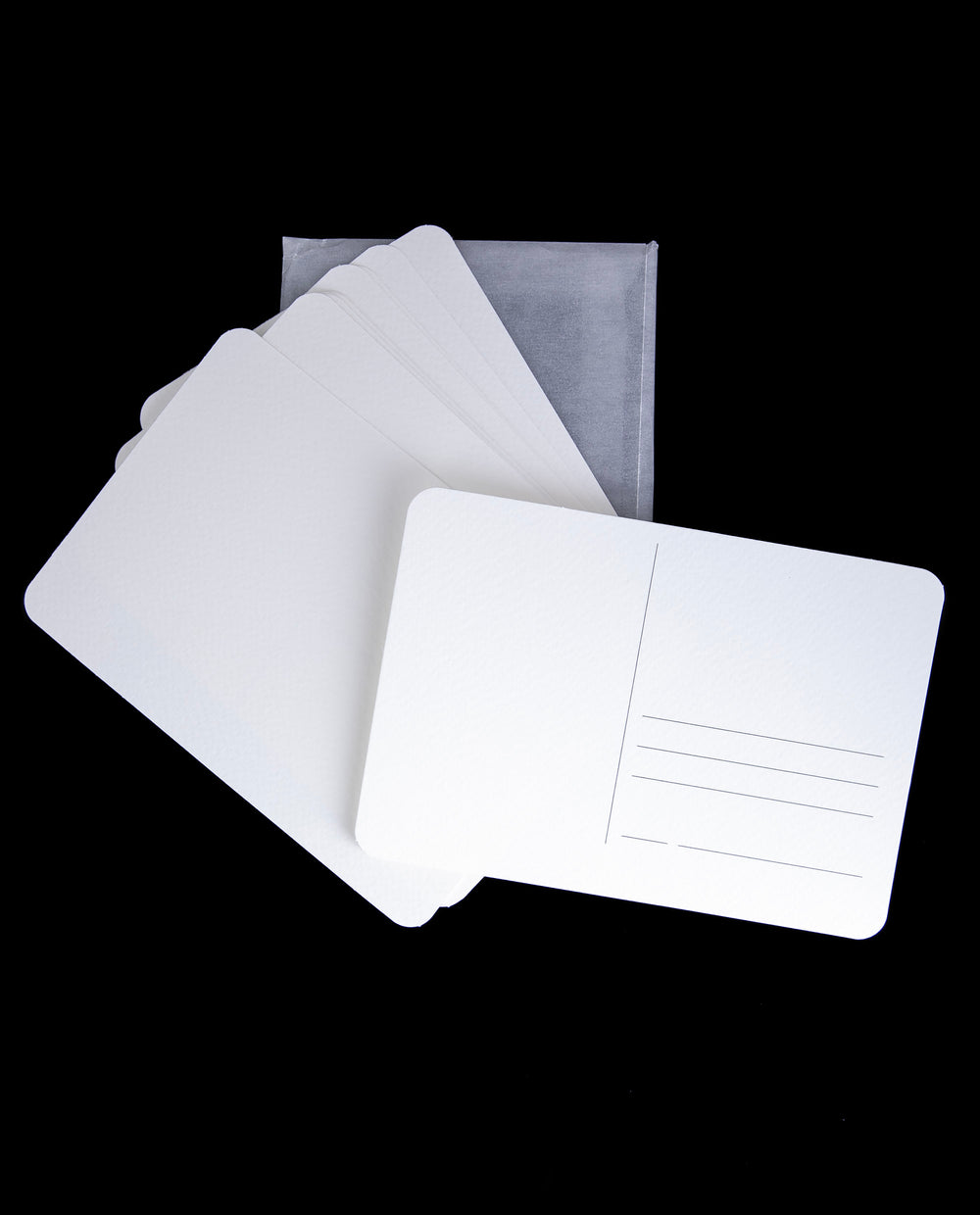 a set of 12 blank white postcards against a black background