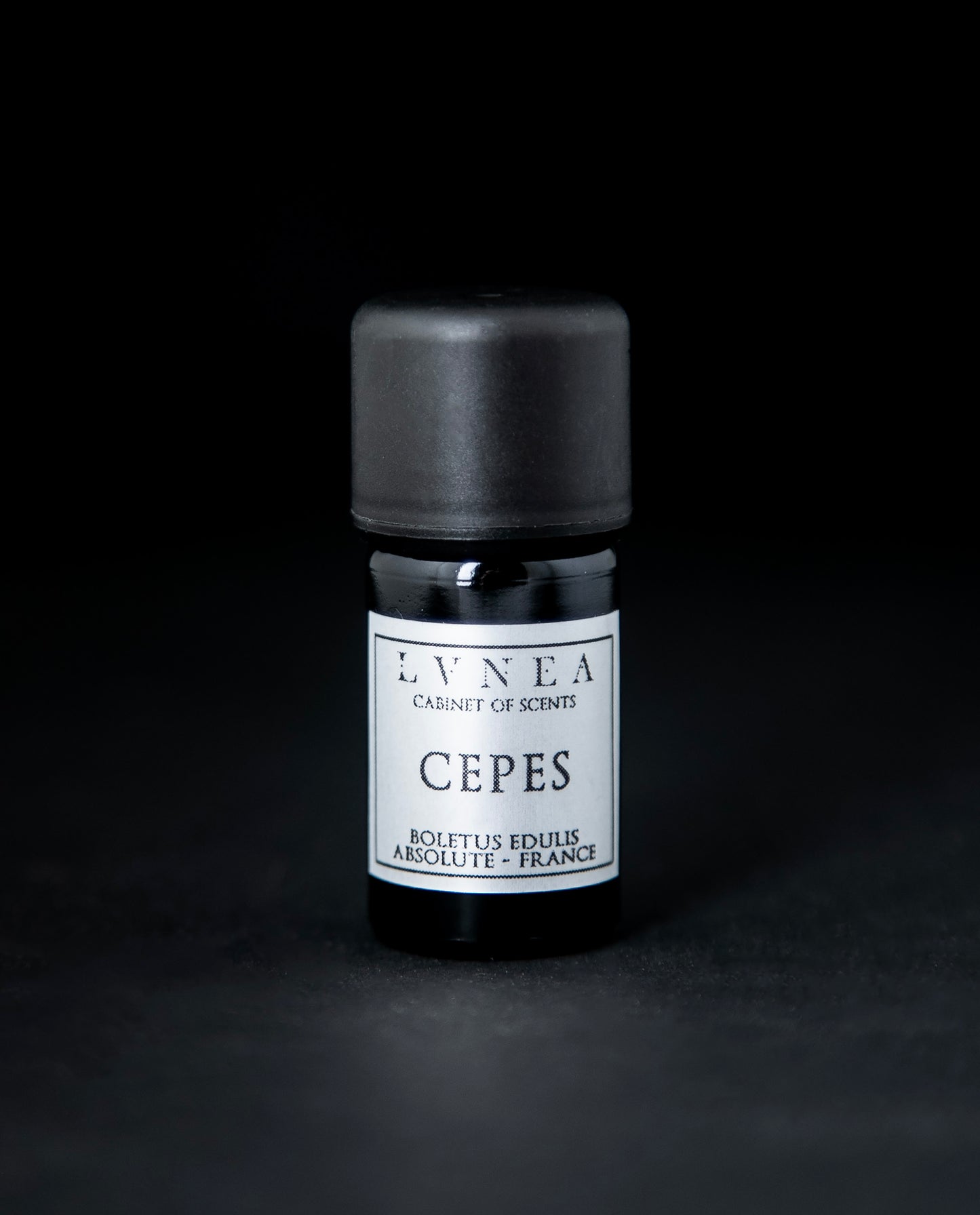 5ml black glass bottle with silver label of LVNEA's cepes absolute on black background