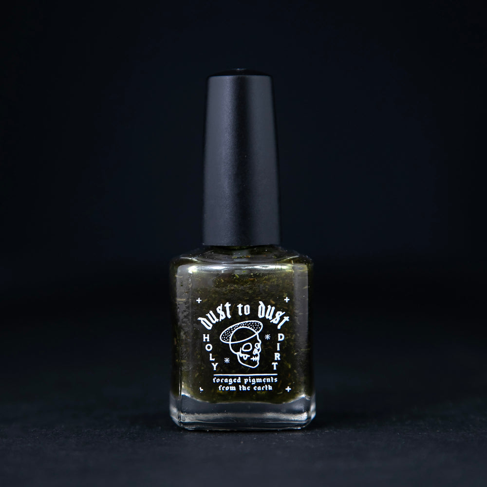 "Dill Weed" nail polish from death valley nails on black background. The polish features bits of real dillweed and is tinted transparent green.