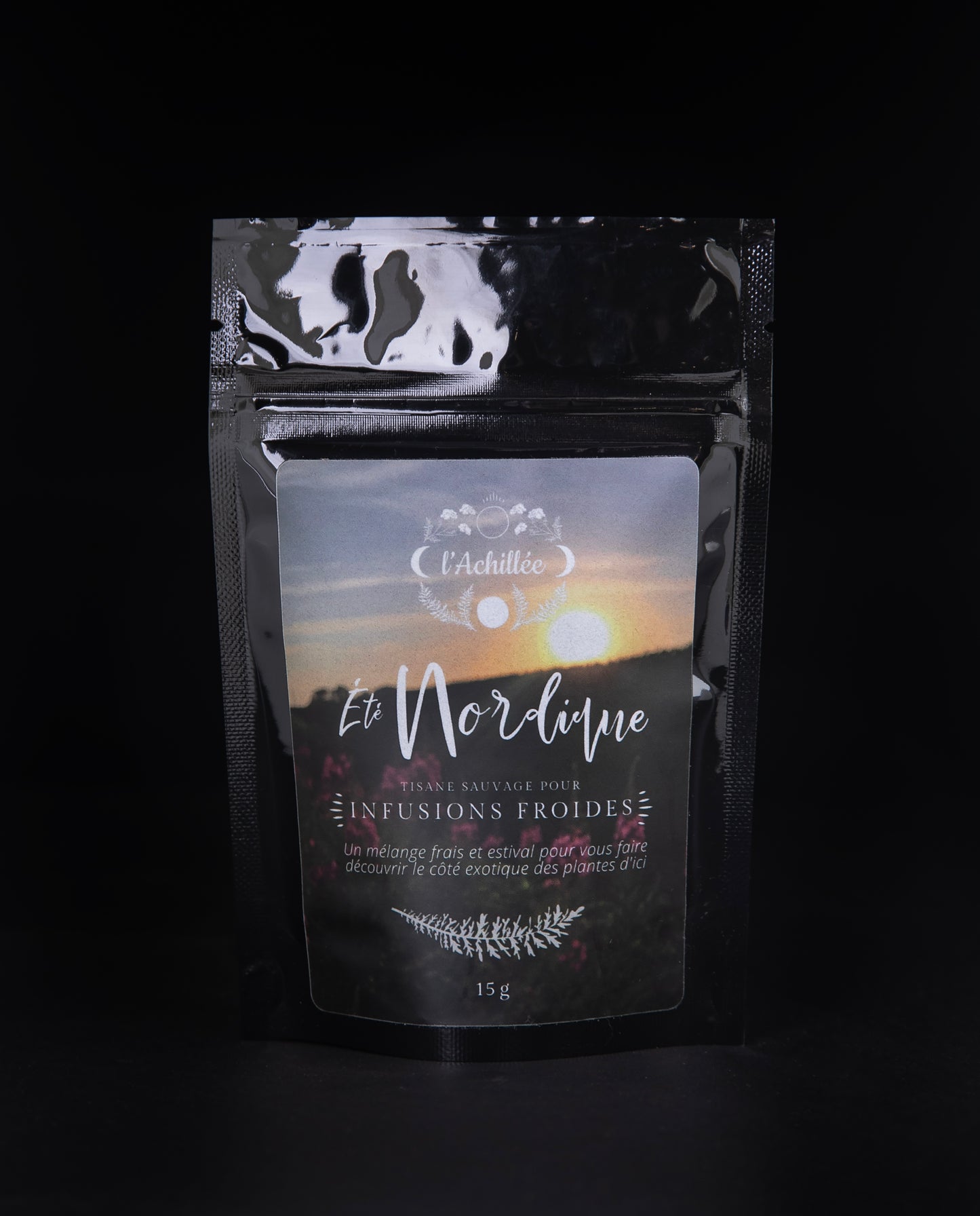 15g black bag of l'Achillée's "Été nordique" tea on a black background