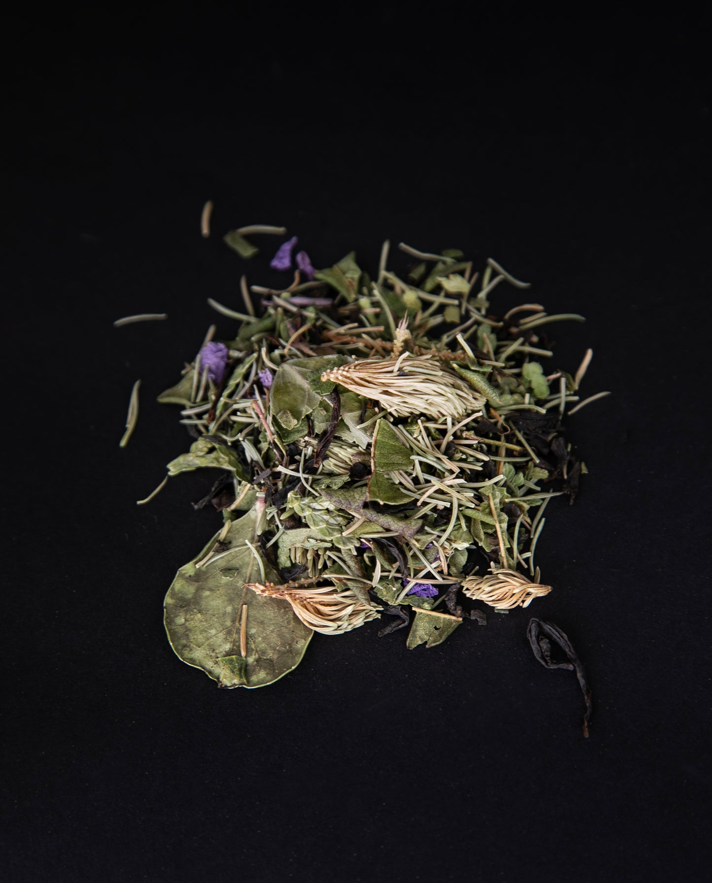 handful of l'Achillée's "Feu de forêt" tea on a black background