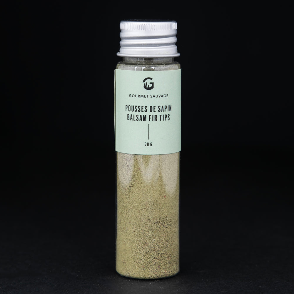 Clear tube of Gourmet Sauvage's balsam fir tip powder, sitting on black background. The powder is a vibrant green colour.