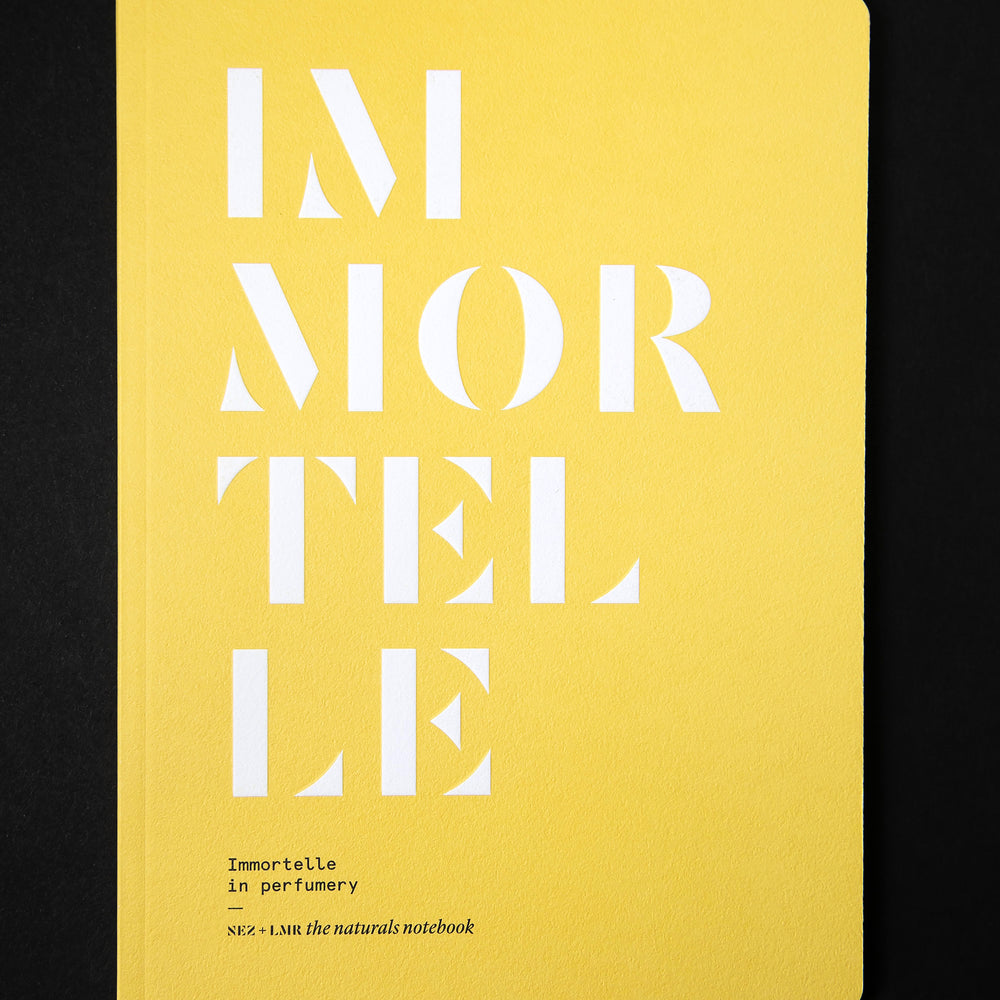 The book "Immortelle in Perfumery" on black background. The cover is canary yellow and reads "IMMORTELLE" in bold white graphic lettering.