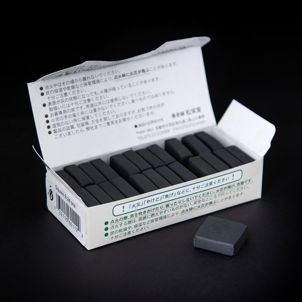 open box of Japanese incense charcoal against a black background