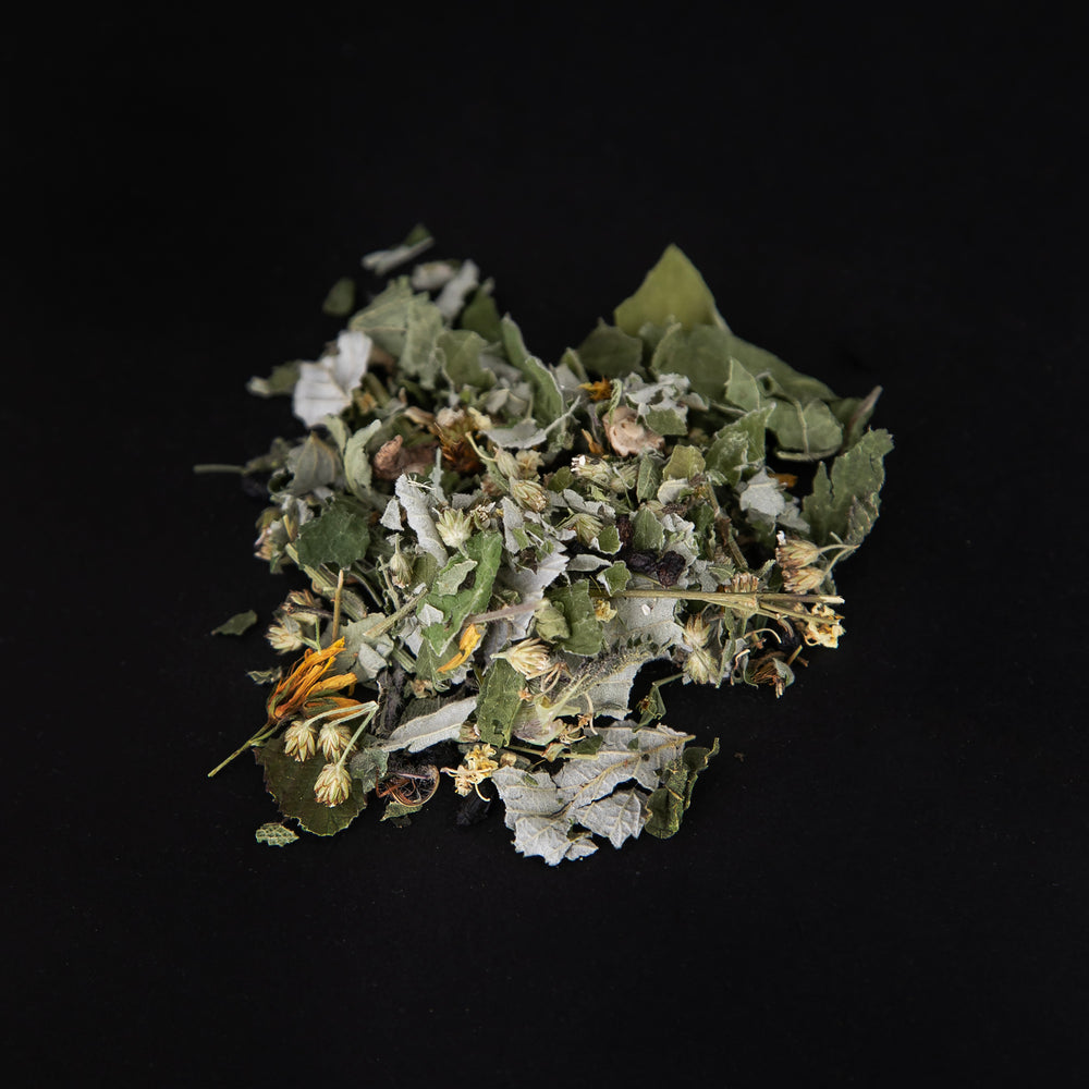 handful of l'Équinoxe loose leaf herbal tea on a black background