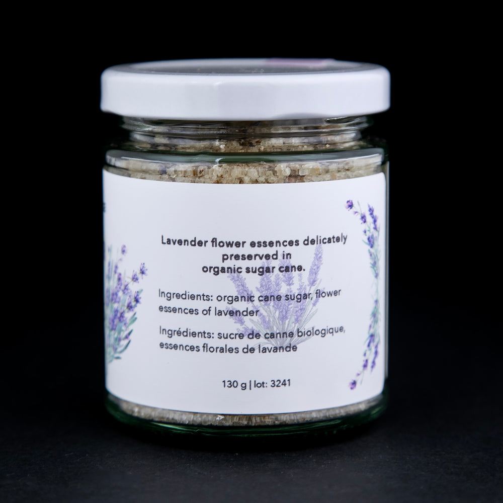 back of a 130g clear glass jar of The New New Age's "Lavender Flower Essences in Sugar". There are illustrations of lavender on the label.