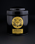 100g black laquered metal canister of Mariage Frère's "Orchidée Magique" tea blend on black background.