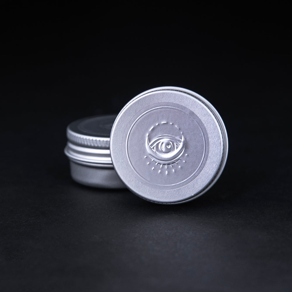 
                      
                        2g sample of LVNEA's "Moon Moss" solid perfume presented in a metal tin. The lid is embossed with an illustration of an eye circled with a crescent moon and sun beams.
                      
                    