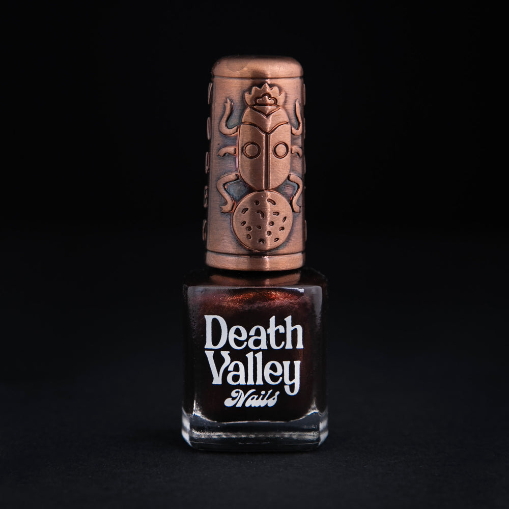 Bottle of "Flying Mud Boat" nailpolish on black background. The colour is a shimmery brown.