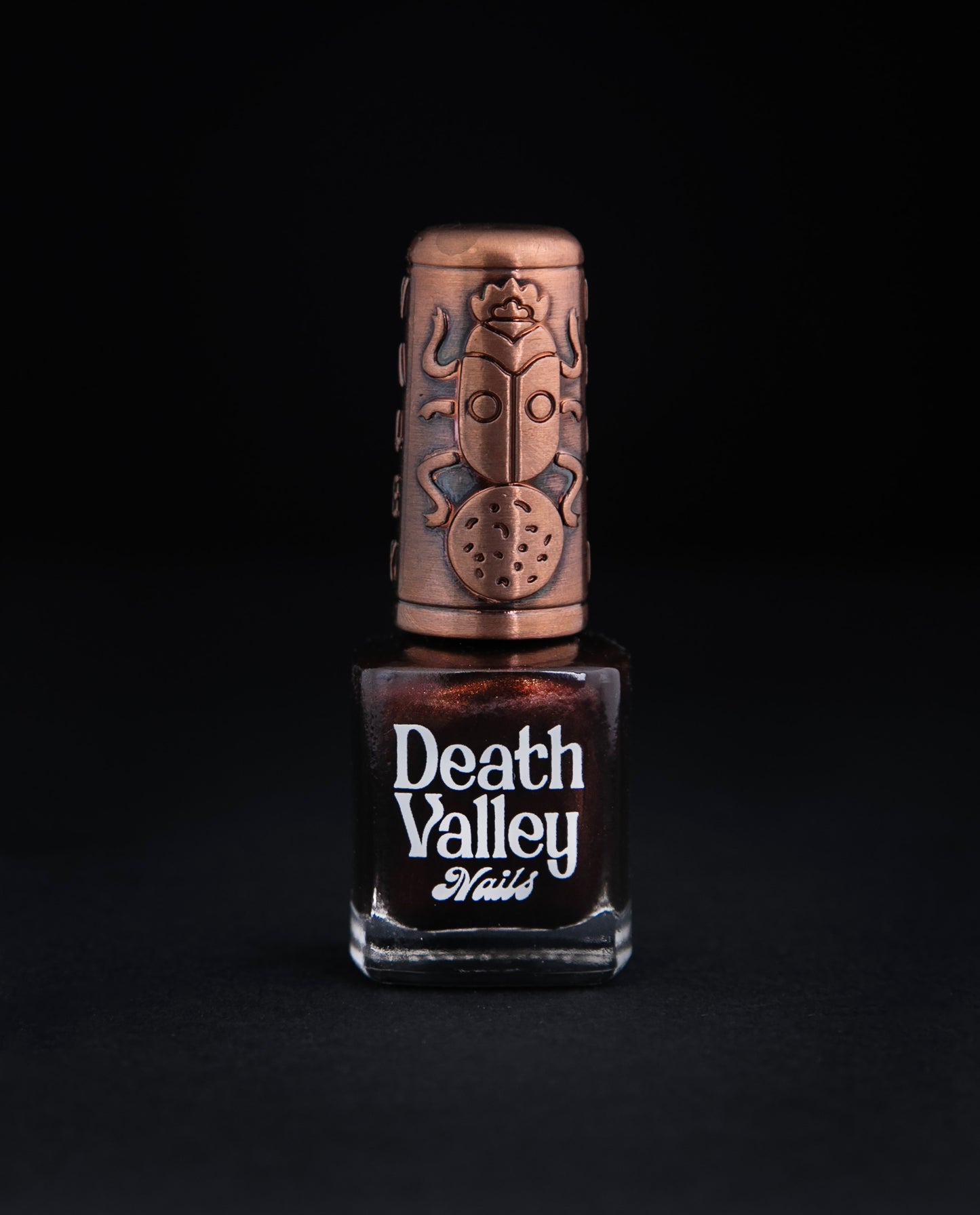 Bottle of "Flying Mud Boat" nailpolish on black background. The colour is a shimmery brown.