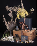 shards of amber-coloured resin piled upon and scattered around a wooden frame against a black background