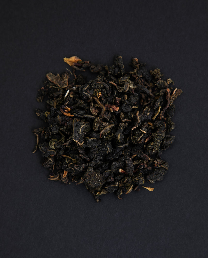 small pile of "orchidee magique" tea viewed from above against a black background