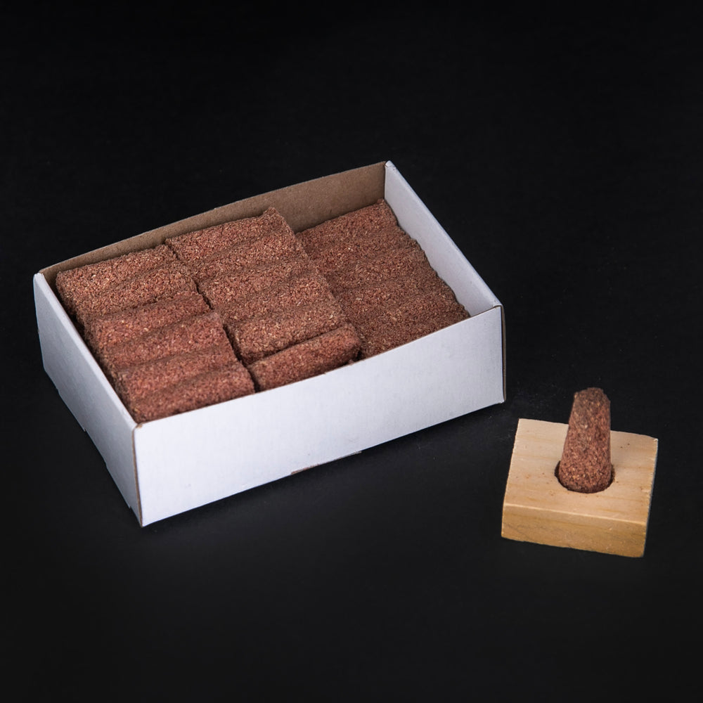 Open box of Paine's Red Cedar Incense cones sitting on black background