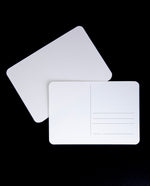 two blank white postcards against a black background