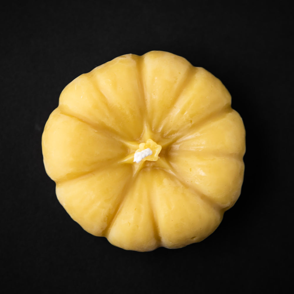 Pumpkin-shaped beeswax candle seen from above.