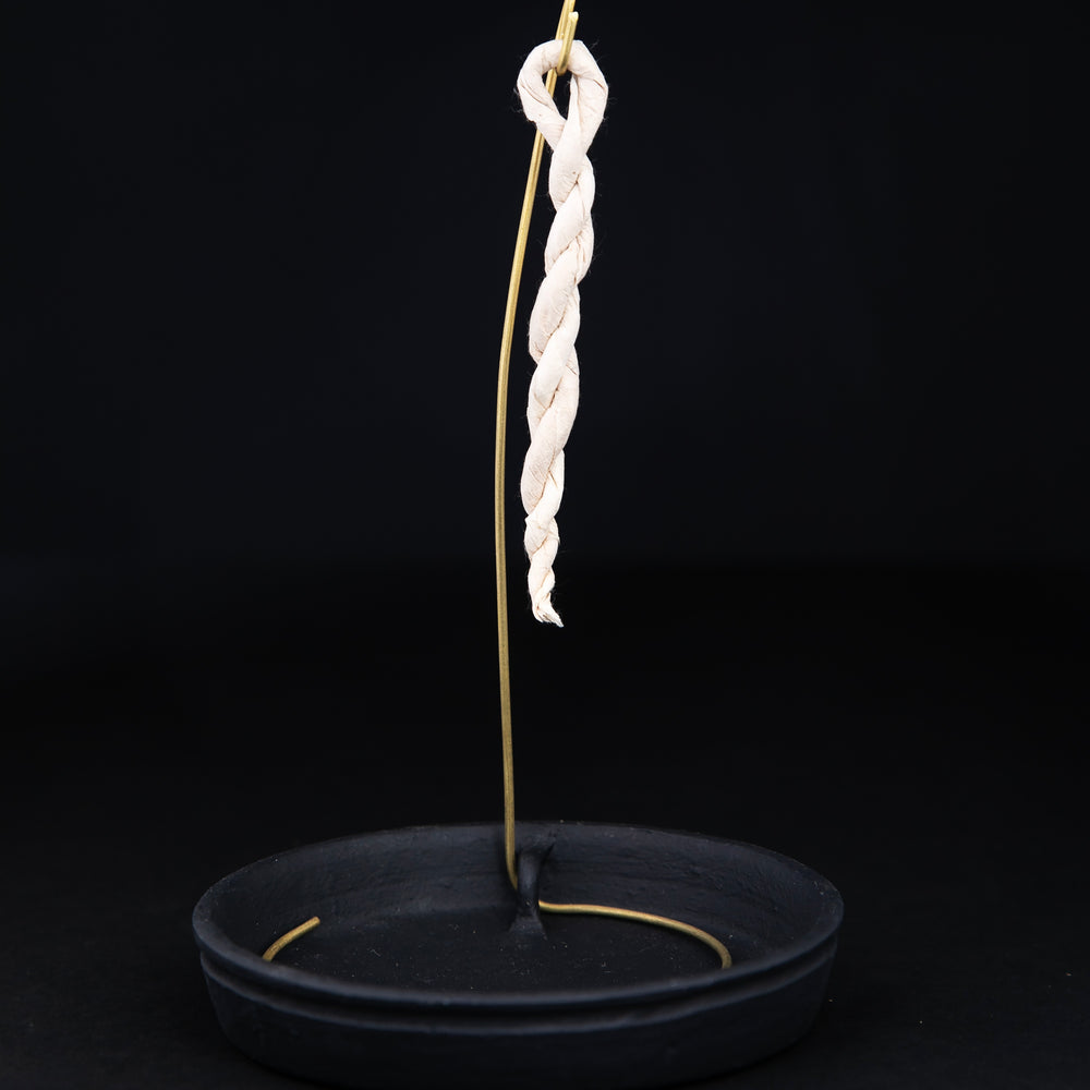 Rope incense holder with black ceramic base plate and brass hook on which to hang rope incense