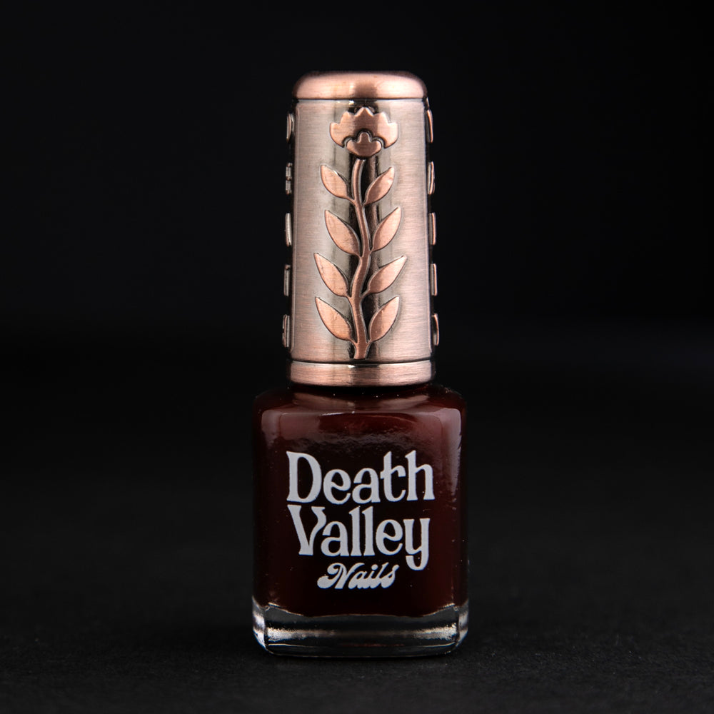 "Swamp Sparrow" nail polish by Death Valley Nails on black background. The polish is a deep cherry red colour with a jelly finish.