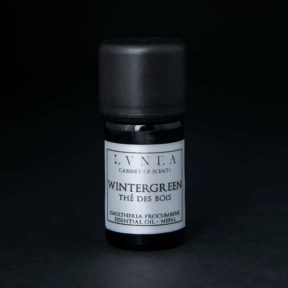 5ml black glass bottle of LVNEA's wintergreen essential oil on black background. The label on the bottle is silver.