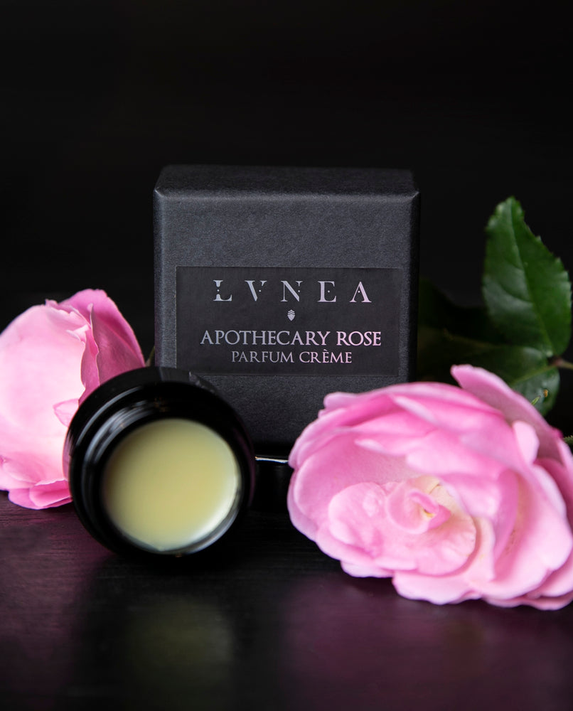 10g black glass jar of LVNEA's Apothecary Rose solid perfume, sitting next to its box on black background