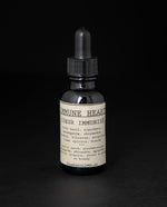 Black glass bottle with dropper top of blueberryjams "Immune Heart" herbal tincture.