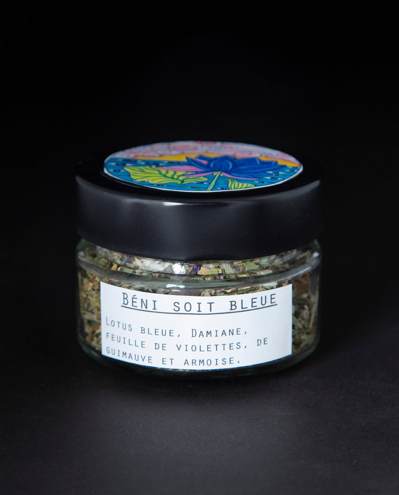 Clear glass jar with black lid containing a blue lotus herbal rolling blend. The white label reads "Béni Soit Bleue"