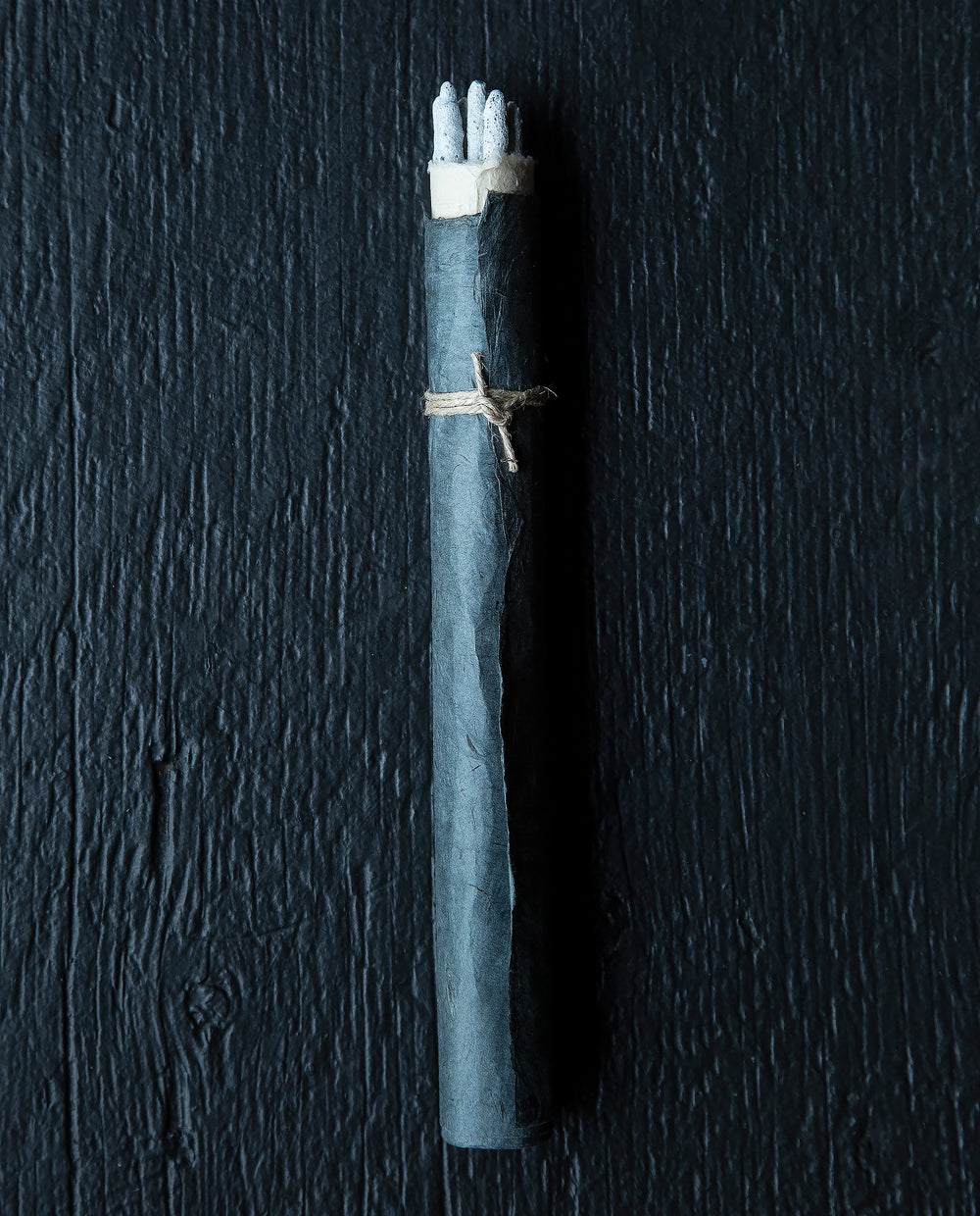 bundle of copal incense sticks wrapped in black natural paper and twine on black wooden background