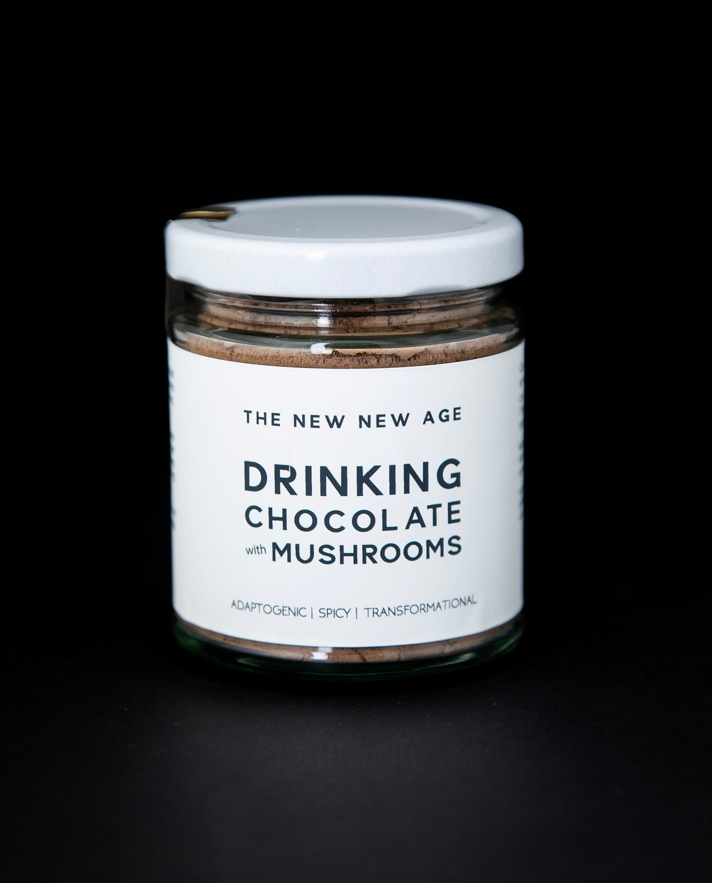 clear glass jar with white lid and white label filled with The New New Age's "Drinking Chocolate with Mushrooms"