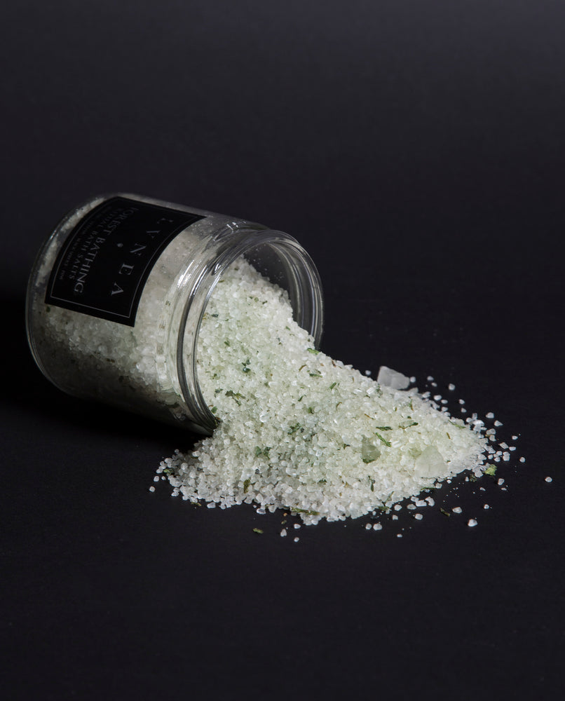 All five of LVNEA's elemental ritual bath salts arranged in a circle and spilling over with colourful salt blends.