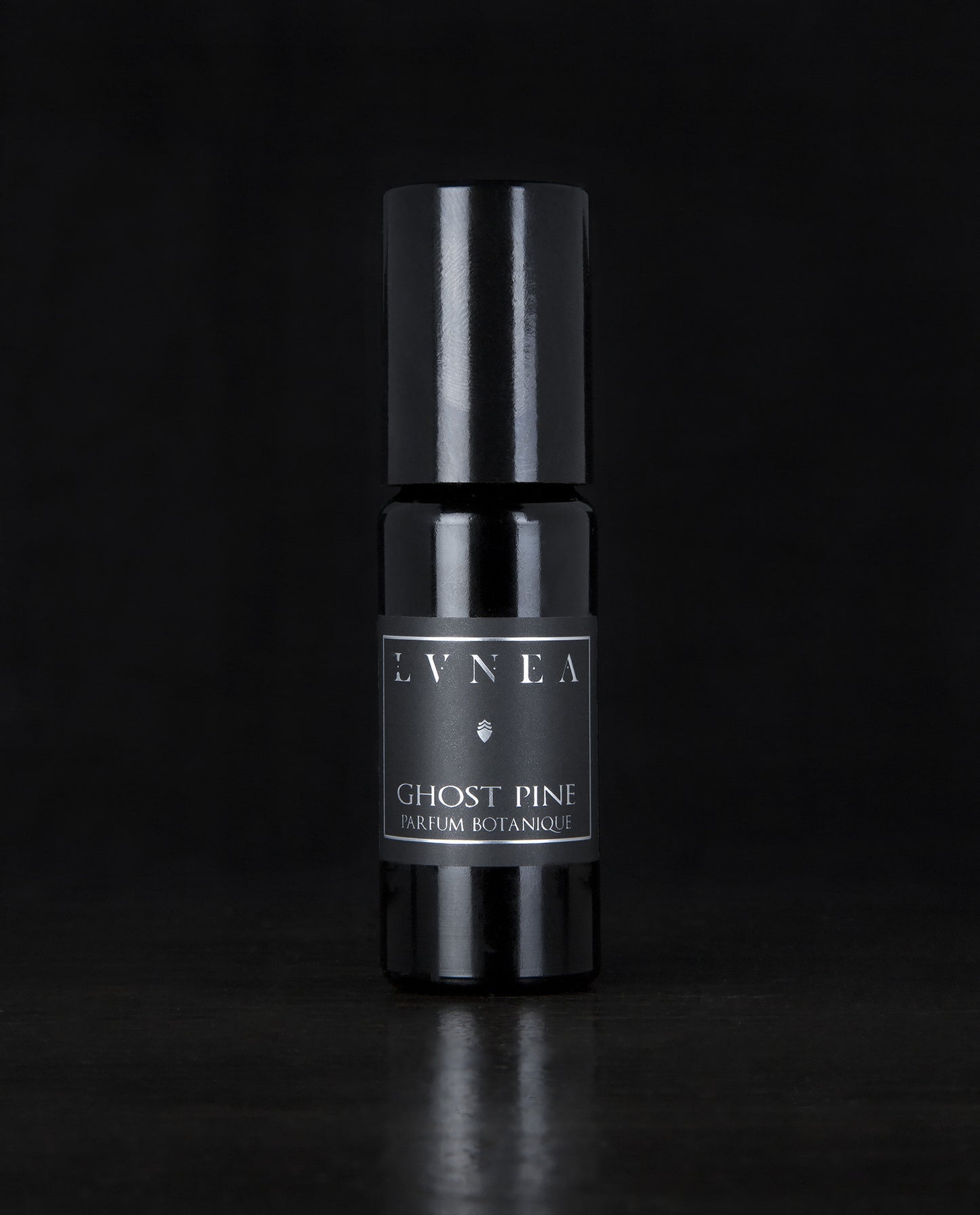 10ml black glass bottle of LVNEA's best-selling Ghost Pine roll on perfume oil on black background