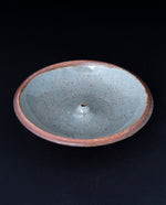 speckled grey glazed stoneware incense holder on black background